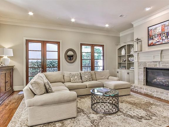 Spacious family room with stone surround fireplace, hardwoods and built in cabinetry.