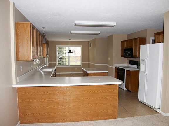 Kitchen with tile floors, and all appliances stay. Updated lighting too.