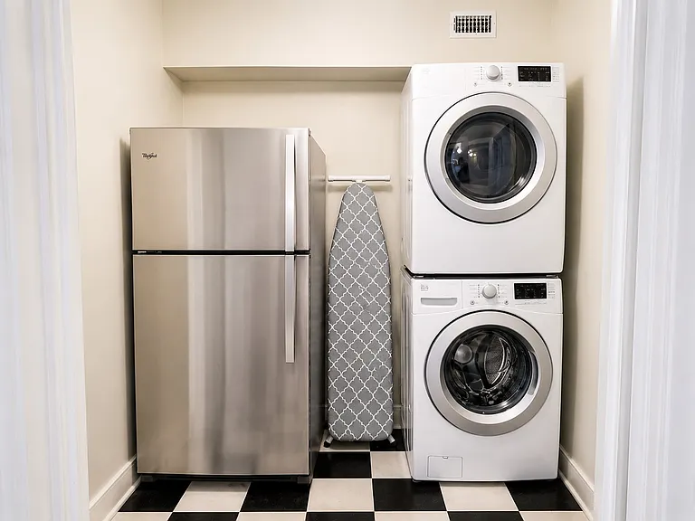 Laundry area with stackable full size front loading washer and dryer, ironing board, and second frig! Pantry is close by this area and is a deep walk in