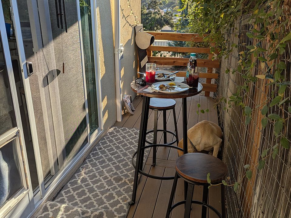 Charming private deck featuring scenic mountain views_perfect for enjoying stunning west-valley sunsets. This inviting outdoor space includes stylish patterned flooring and room for seating, offering a quiet retreat directly off the kitchen.