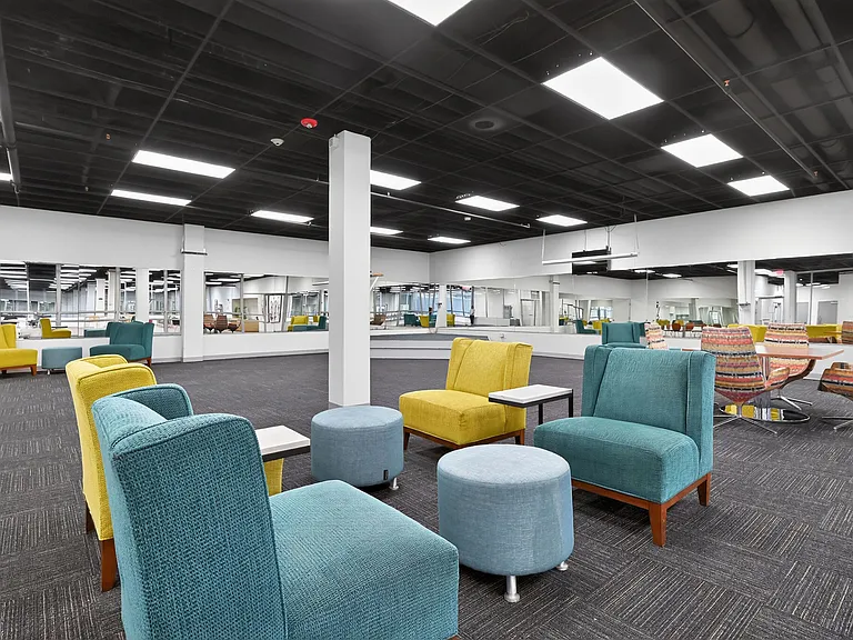 Modern lounge area with vibrant seating and mirrored walls in a spacious community room, perfect for social gatherings.