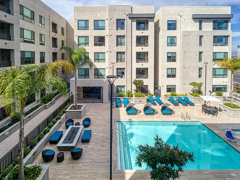 Resort_inspired courtyard pool with shaded seating and greenery offering a bright outdoor hangout.