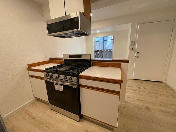 New gas Kitchen stove and dining area on other side. Front door.