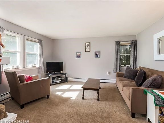 Large freshly painted sun-filled family room with a wood burning fire place.