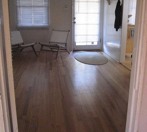 Living room hardwood flooring facing front door with furniture removed