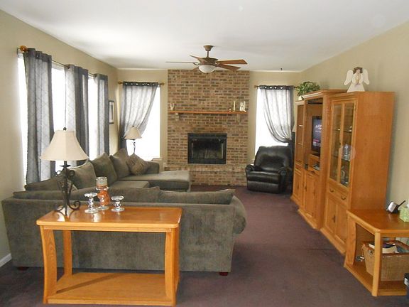 Family Room : Floor to ceiling brick wood burning fire place, triple hung window, ceiling fan