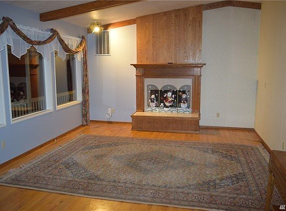 Living room with vaulted ceilings plenty of windows and gas fireplace.