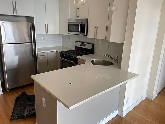 Clean, functional kitchen with updated appliances. The dishwasher is under the counter. Washer and dryer are in-unit,, not shown. This kitchen has great storage and lighting.