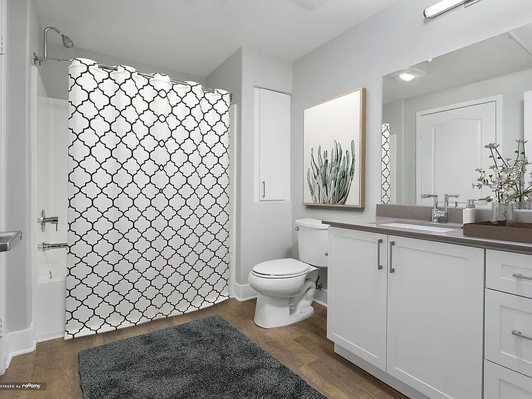 Renovated Package I bath with white cabinetry, grey quartz countertop, and hard surface flooring