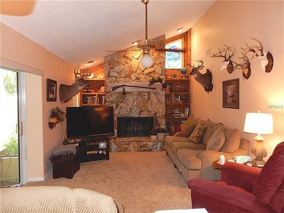 Family Room with wood burning Fireplace and sliding doors that exit out to the Covered/Screened Lanai
