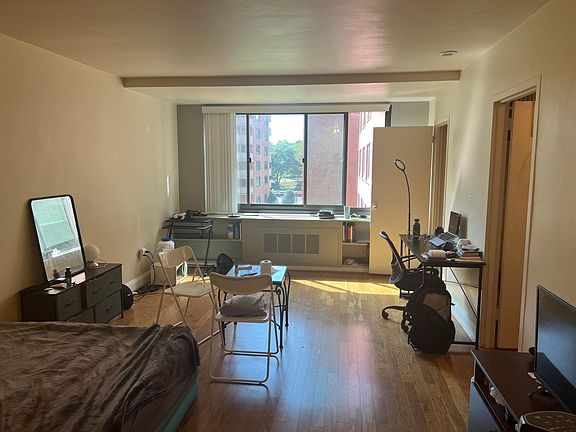 Overview of studio as you walk in the door. Kitchen door is near window. Closet leading to bathroom is the other door on the right. (As decorated by a previous occupant)