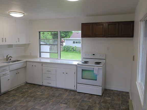 Open and bright kitchen with new dishwasher, refrigerator, solid surface countertop and sink. Plenty of room for a nice kitchen table.
