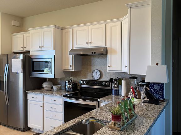 Spacious eat-in kitchen, granite and stainless steel appliances, electric stove.