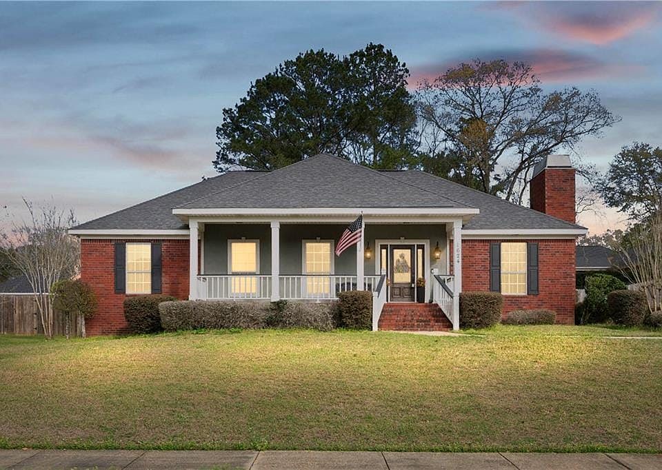 Bungalow-style house featuring covered porch, a front lawn, and roof with shingles. Digitally Altered.