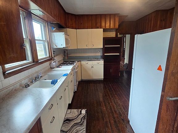 Freshly painted kitchen with full refrigerator and microwave and new stove