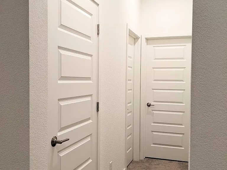 Efficient and organized floor plan. The hallway provides seamless access to all your essentials: private laundry room (first left), bathroom (second left), dedicated storage (right), and the spacious bedroom straight ahead. Everything at your fingertips.