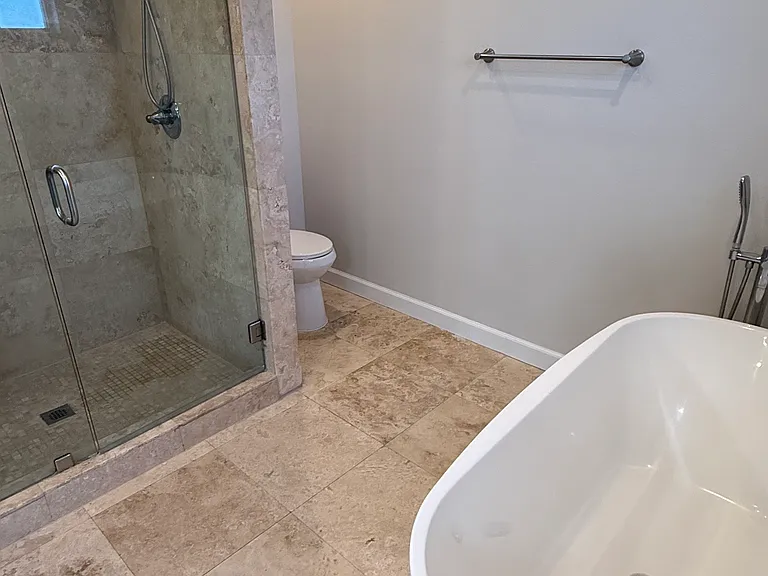 Primary bathroom with bathtub, shower and his-and-hers sinks