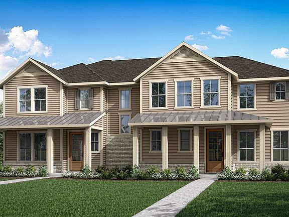 A two-story residential house with a gabled roof, wooden siding, and a well-manicured lawn in the fo