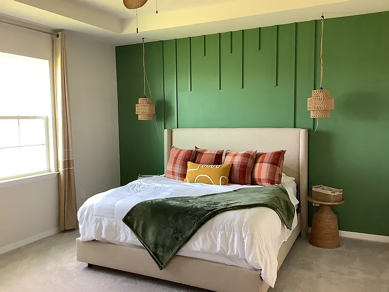 "Spacious primary suite featuring a king bed, walk in closet, en suite bathroom and natural light"