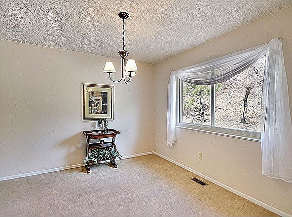 The din rm features neutral carpet & a large window for natural light.