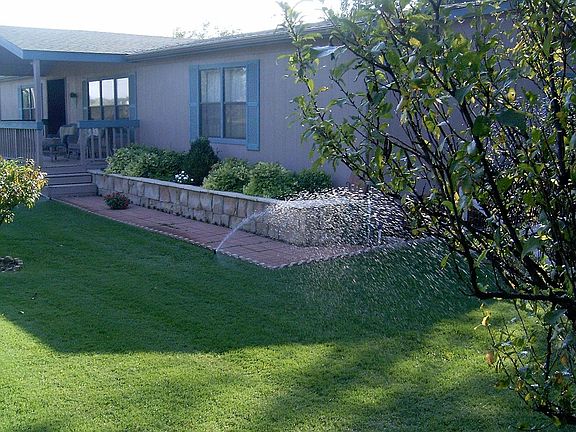 ne front corner w/sprinklers running