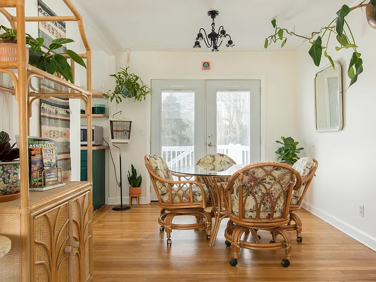 View of dining area. Double doors with interior blinds open to the wrap around porch, on the back of the house. There are also double doors in the kitchen.