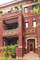 Balcony looks out onto tree-lined street.  Note stained-glass window