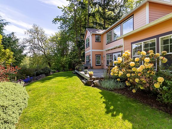 A large deck with motorized retractable awning overlooks the back lawn.