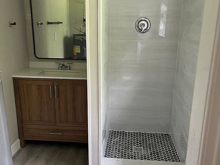 Lovely renovated bathroom with custom shower tiles and vanity