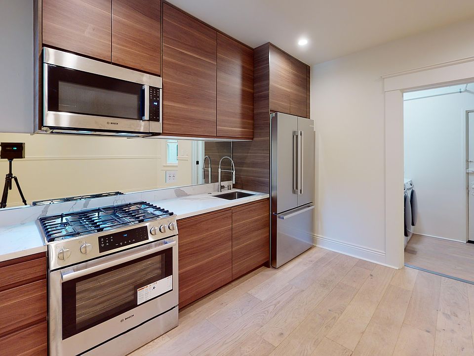 Kitchen with multiple cabinets, refrigerator, stove, microwave oven, and sink