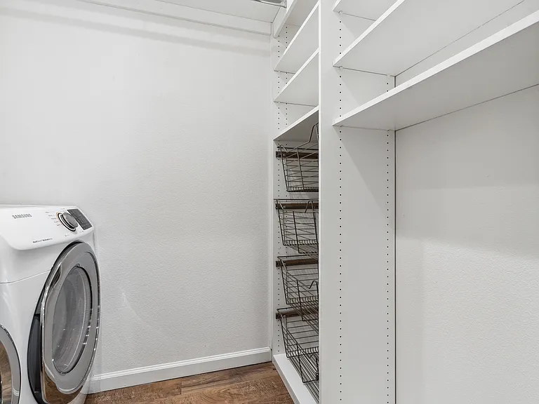 Laundry room with newer washer and dryer; customizable cabinets and storage. Hanging laundry bar.