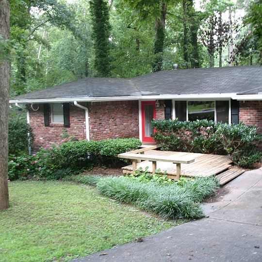 Front of house with porch with bench seating.