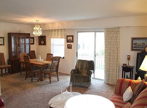 View of family room and dining room with elegant chandelier.