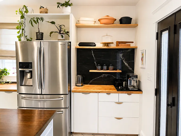 Gourmet kitchen with black granite backsplash, stainless steel appliances, butcher block counter tops and custom 8-foot wooden waterfall island