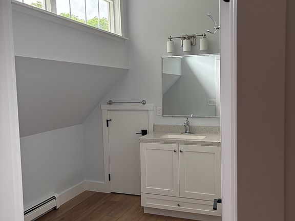 Looking into bathroom. Small door to left of sink is access for storage