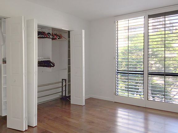 Bedroom with lots of light and wall of closet space.