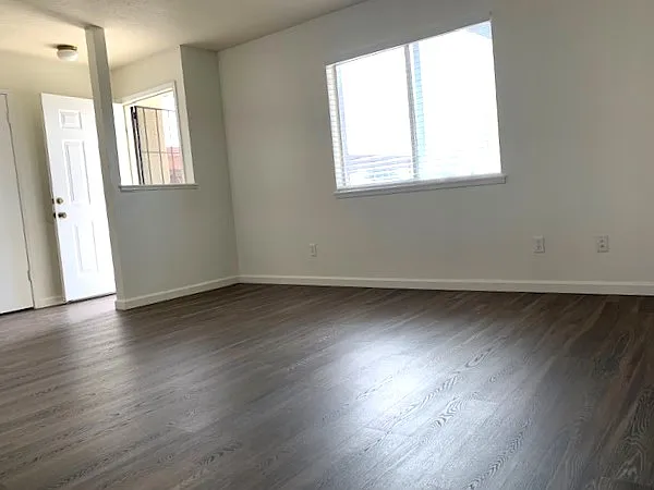 Living room with new flooring, great natural light and security screen.