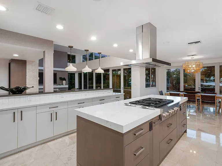 Chef's kitchen with stainless steel appliances, quartz countertops, and a sleek island with bar seating.
