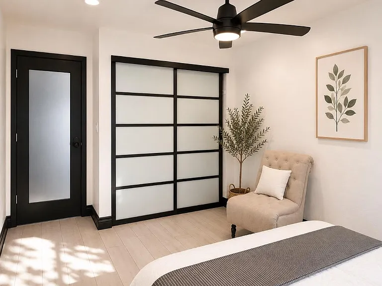 Bedroom with ceiling fan light, large sliding closet doors, and an accent chairideal for relaxing and easy storage.