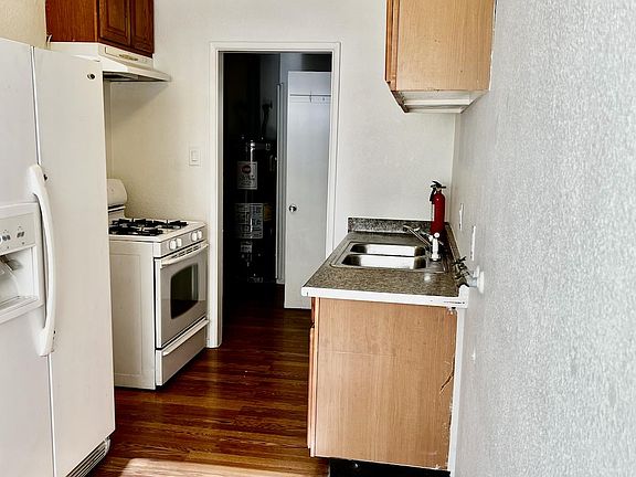 Alley kitchen with nice size refrigerator