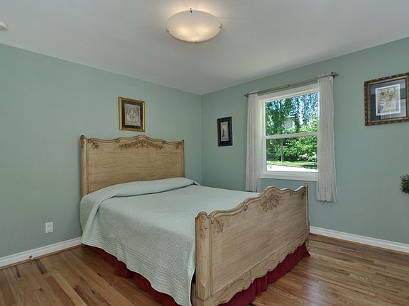 Spacious and light filled bedroom with hardwood floors.