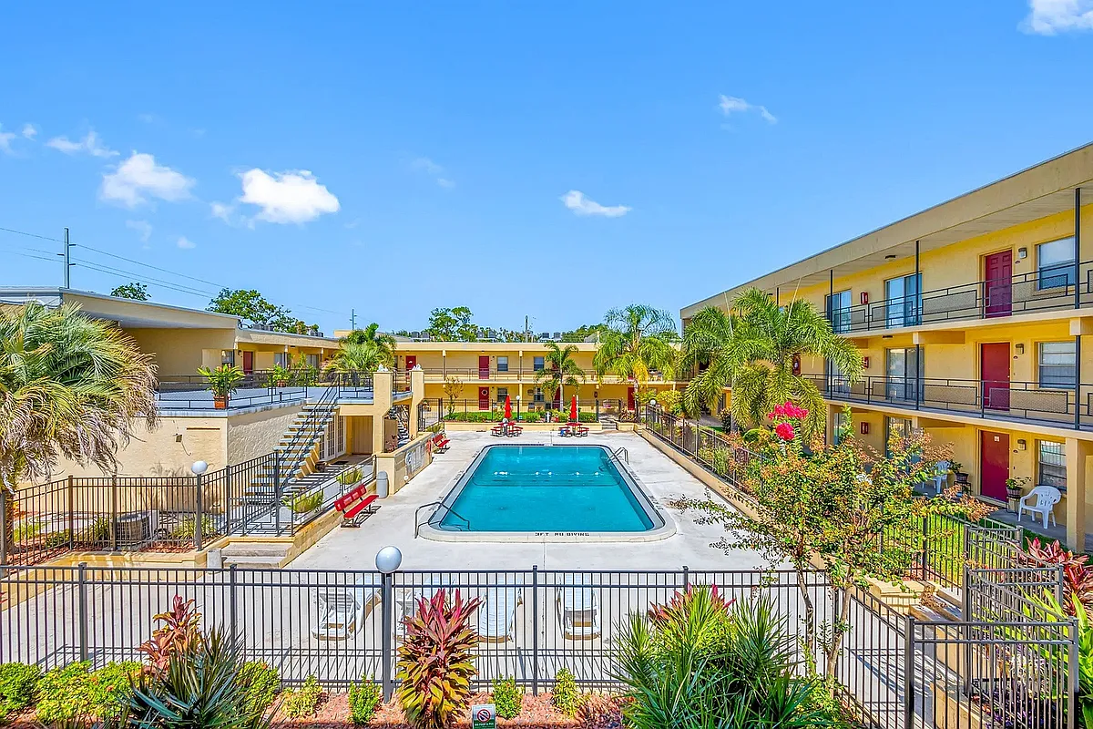 Vibrant apartment community featuring a luxurious outdoor pool, surrounded by lush tropical landscaping and modern amenities. - Parkview Apartments