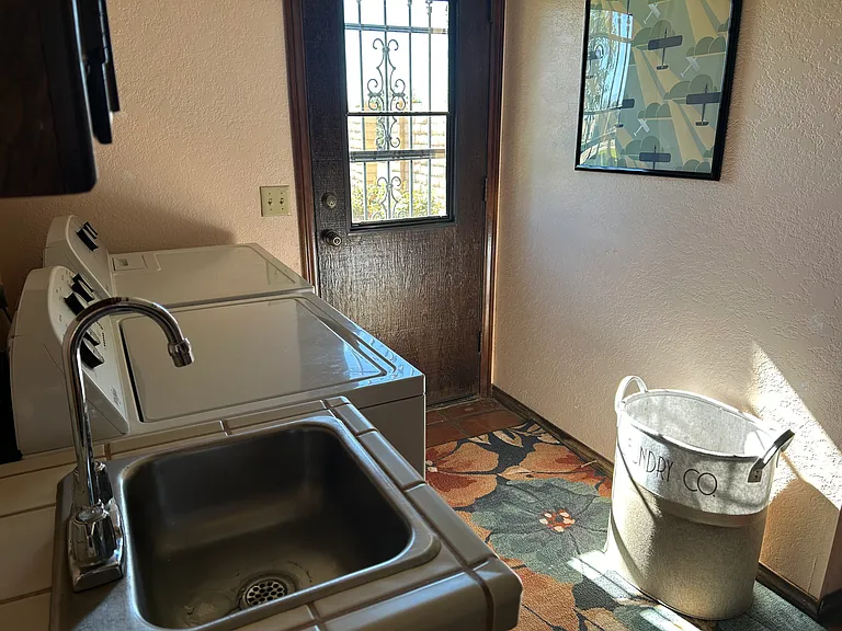 Laundry room off kitchen. New washer & dryer plus sink. You'll find an iron and ironing board here.