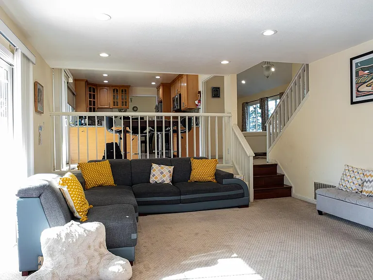 Family room with carpets before which have now been replaced with wooden flooring