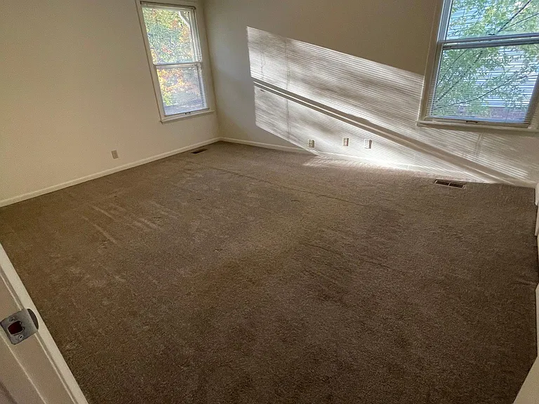 This is the second bedroom on the main level. It also has windows with the mini blinds for your convenience. The views outside the windows are beautiful looking through the trees limiting the view of the house next door.