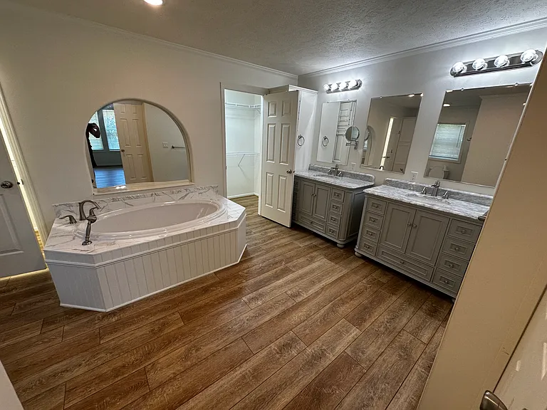Master bath with Jacuzzi tub and movable shower head. His and her sinks. Two entries to walk in closet, one on each side of the closet.
