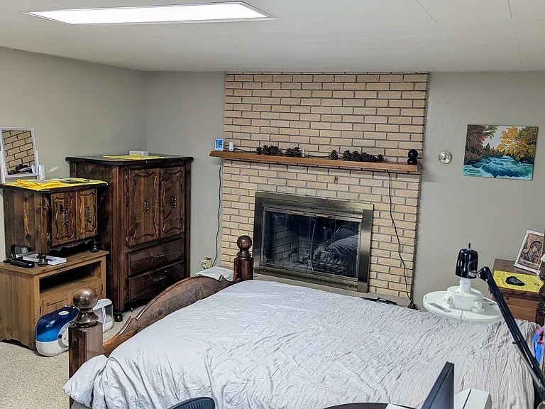 North wall of BR1 with 2 dressers, nightstand, Queen bed, Fireplace