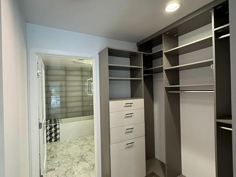 California closet system with hamper, multiple hang rods and floor to ceiling shoe shelves