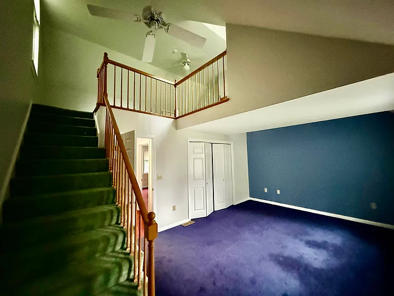 View of primary bedroom and loft, ceiling fans