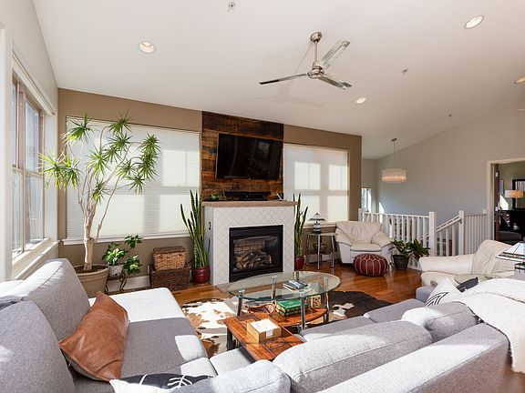 Large sectional couch surrounding gas fireplace and large 65" LED TV.